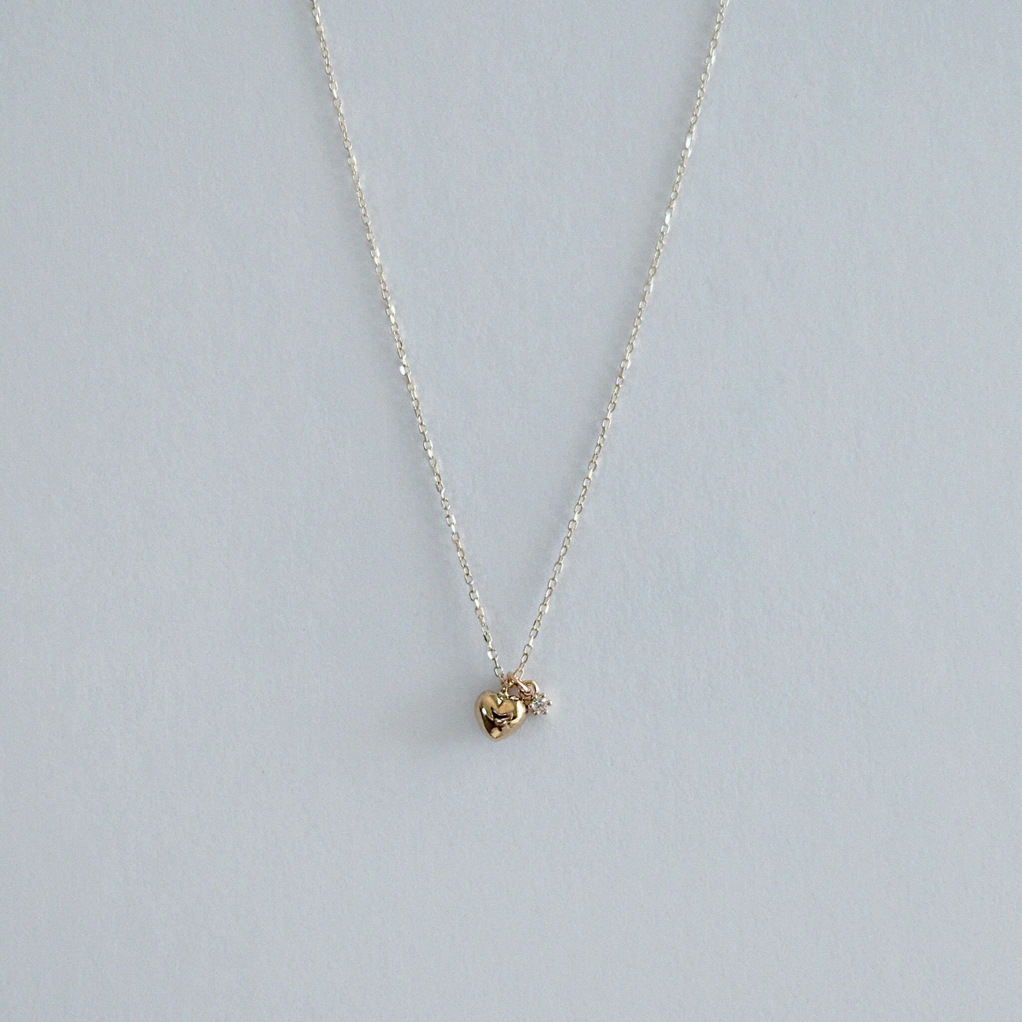 14K Solid Gold Amour Necklace displayed against a clean backdrop, highlighting puffed heart and sparkling cubic zirconia