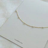 Elegant bracelet resting on textured surface with simple branded card