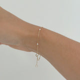 Freshwater pearl and gold chain bracelet gently draped on wrist