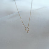 Minimalist display of the Circle with Diamond Necklace highlighting the textured gold and sparkling diamond