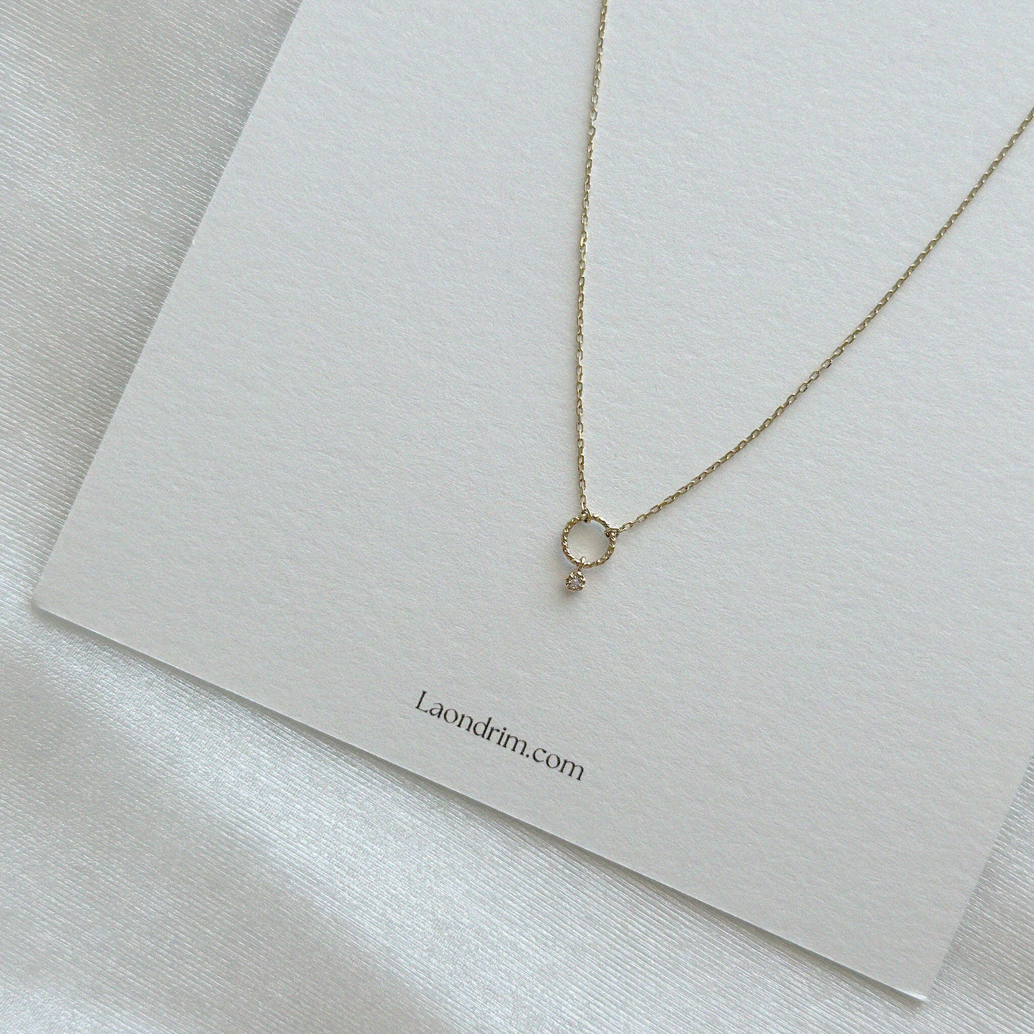 Close-up shot highlighting the fine polish and diamond brilliance of the circle charm