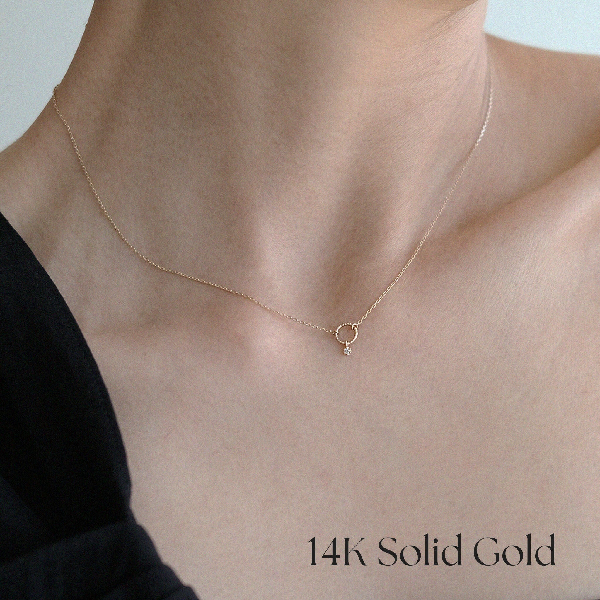 Close-up shot of model wearing the 14K Circle with Diamond Necklace, styled with an off-shoulder black top for a refined look