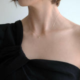 Elegant neckline shot showing how the circle pendant rests just below the collarbone