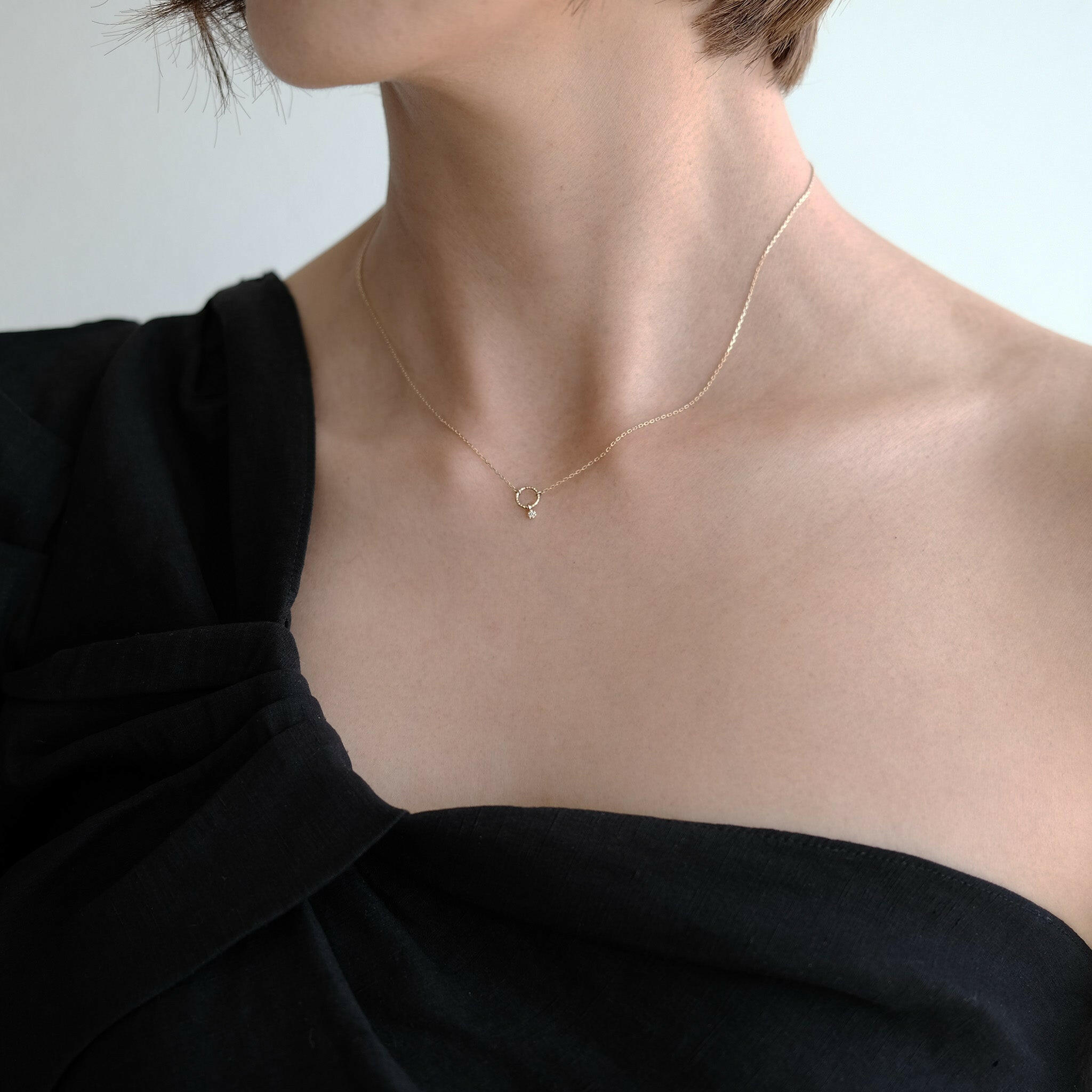 Elegant neckline shot showing how the circle pendant rests just below the collarbone