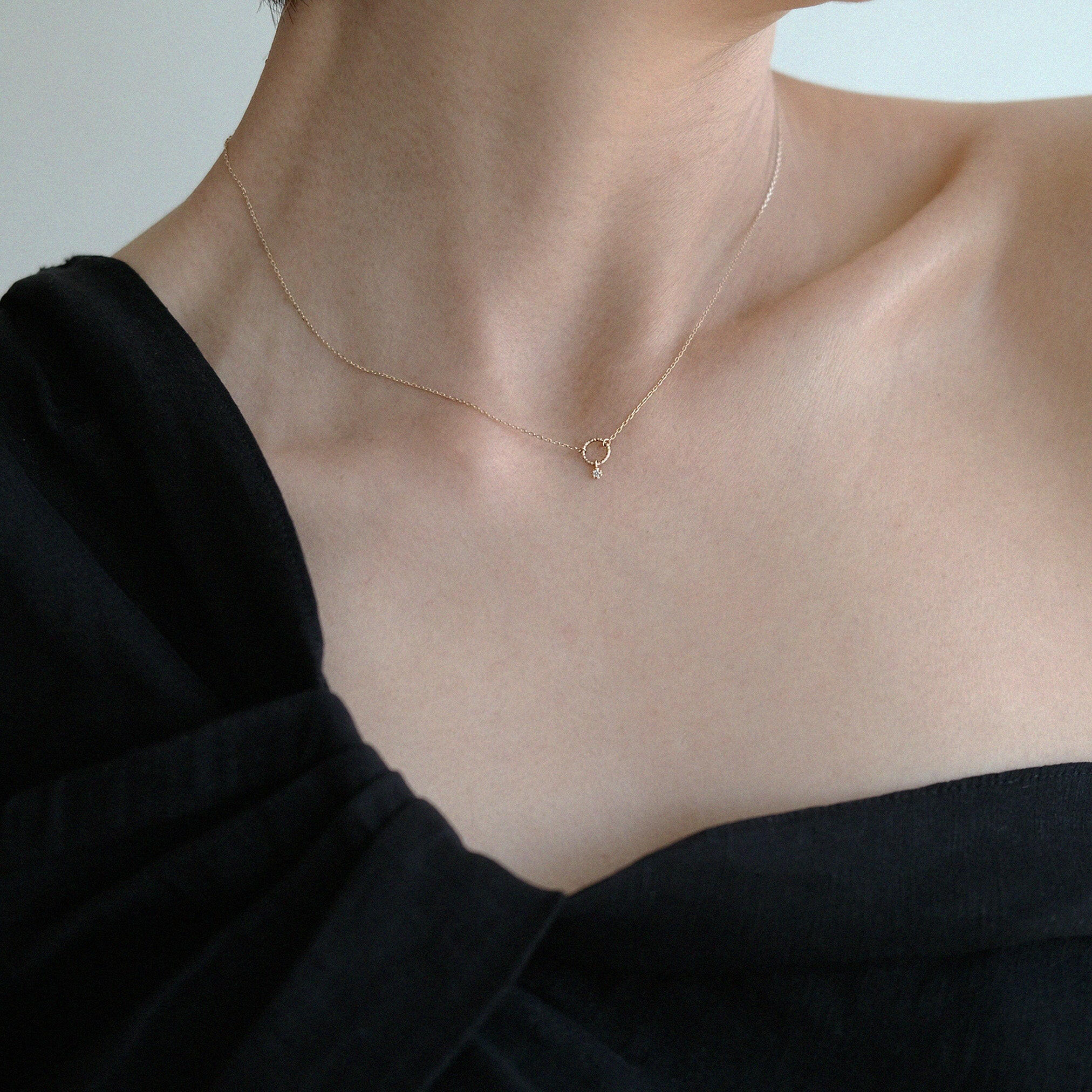 Model wearing the 14K Circle with Diamond Necklace, styled with an off-shoulder black top for a refined look