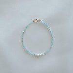 14K Gemma Beads Bracelet arranged on a beige stone tray with pearls and gemstones