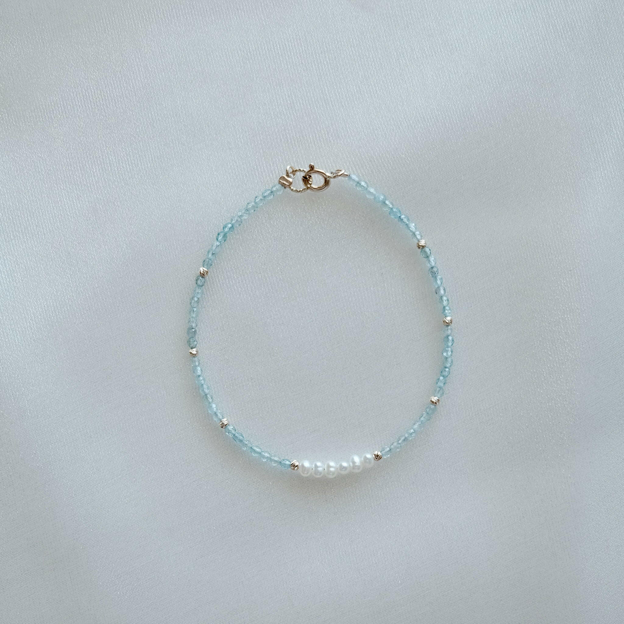 14K Gemma Beads Bracelet arranged on a beige stone tray with pearls and gemstones