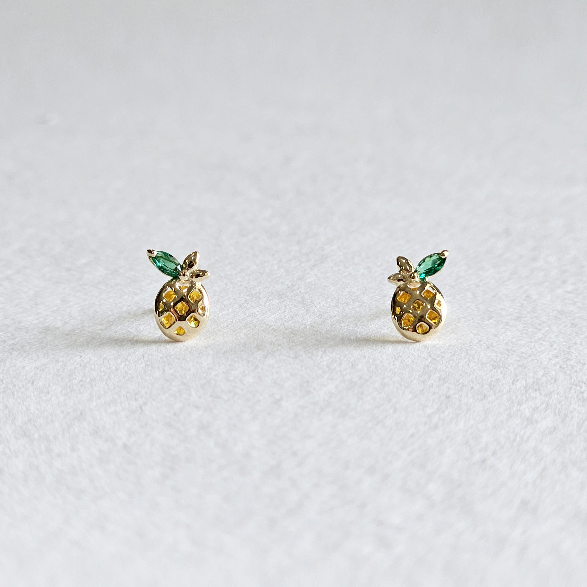 Gold pineapple earrings shown head-on with multi-color sparkle