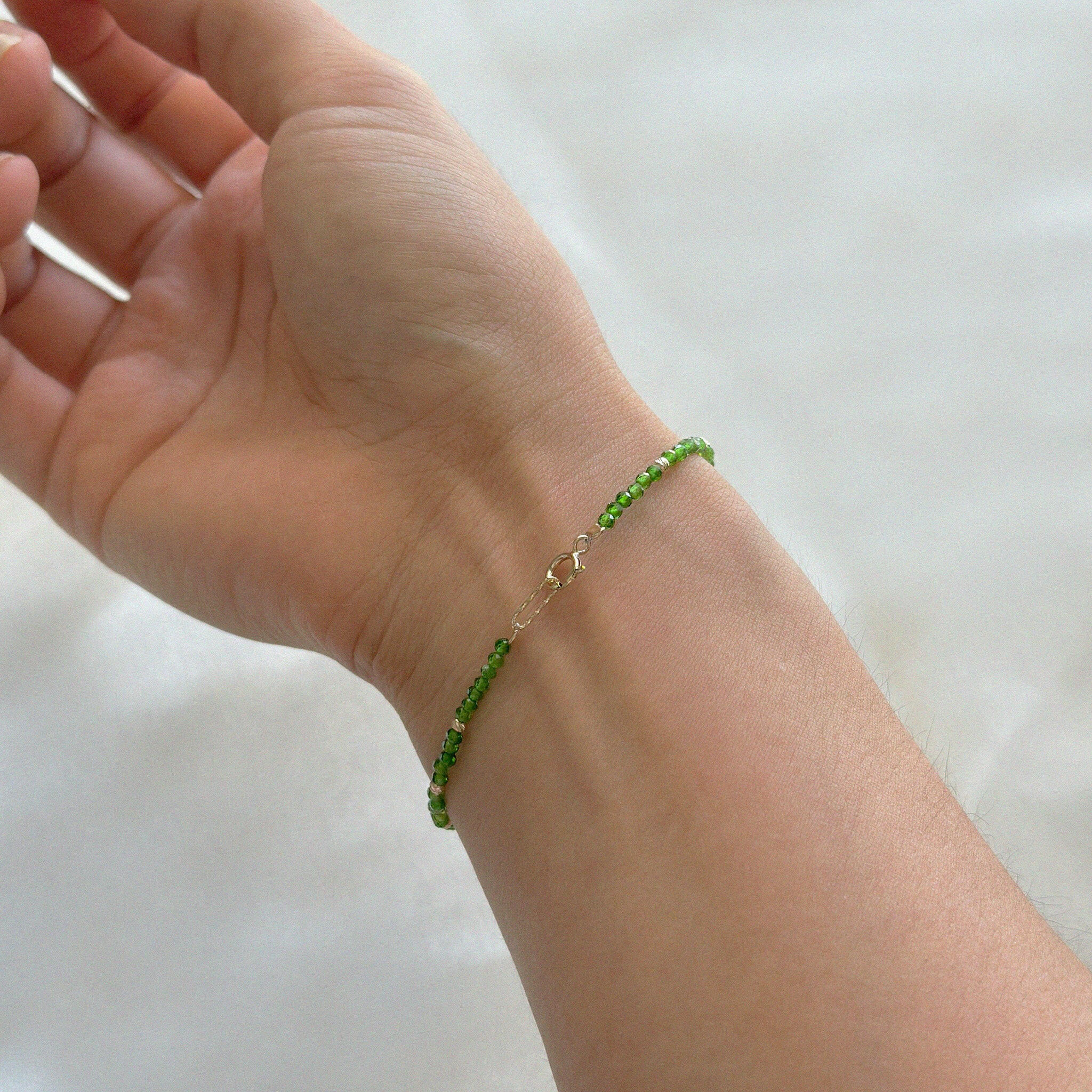 Close-up shot of model's wrist, 14K gold clasp and bead accents on the Prato Bracelet