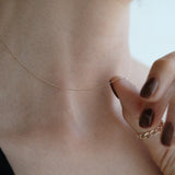 Minimal gold chain necklace styled for everyday wear, paired with black attire for modern elegance