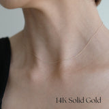 Close-up shot of model wearing the 14K Tiffany Chain Necklace with a black off-shoulder top, emphasizing the delicate neckline.