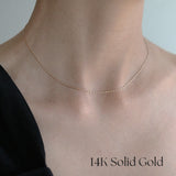 Close-up shot of model wearing the Twist Box Chain Necklace over a black off-shoulder top for a minimal yet striking contrast