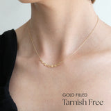 Model wearing 7 disc necklace alone as a dainty statement piece