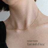 Model wearing box chain necklace alone with minimalist styling