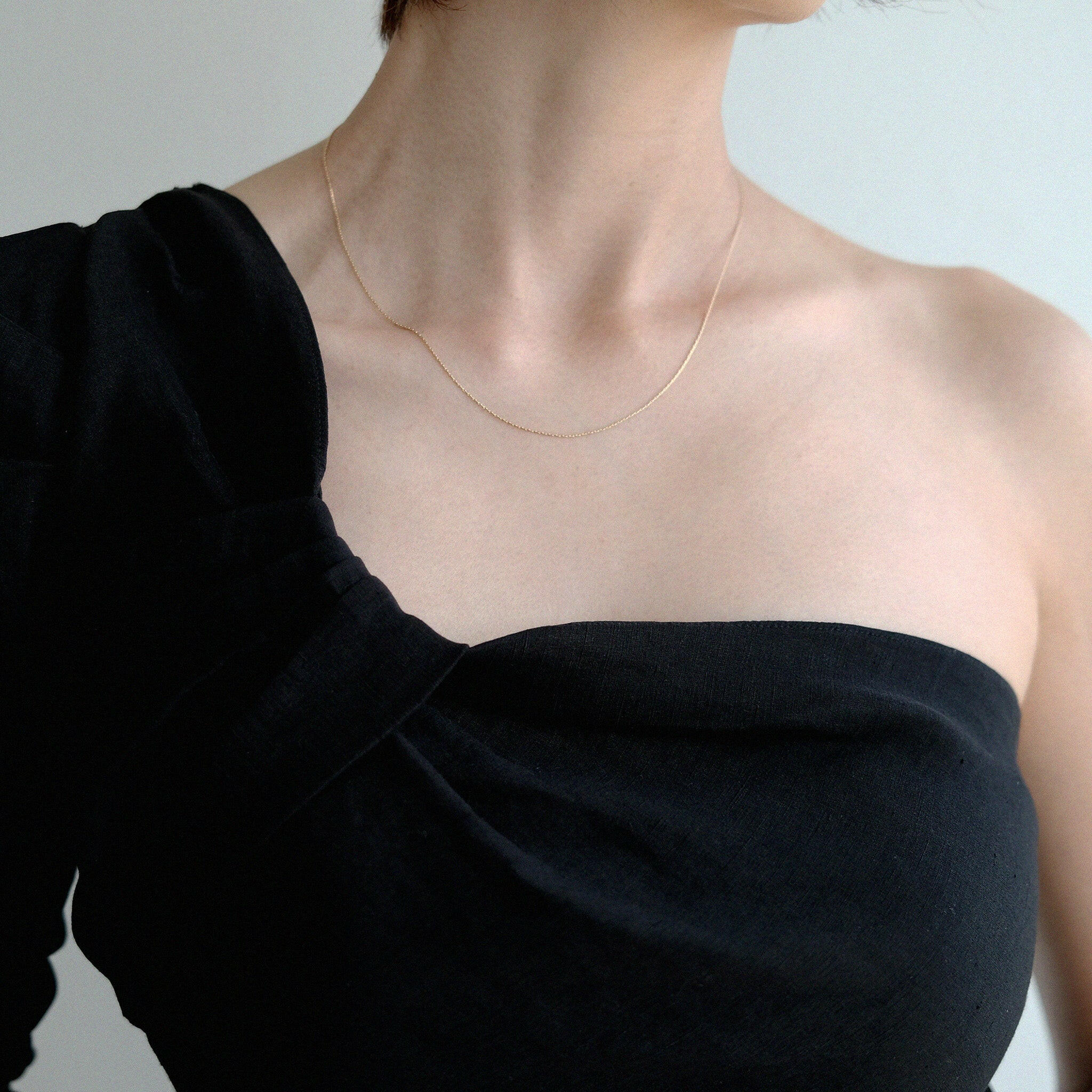 Model wearing cable chain necklace alone with black outfit