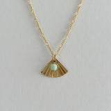Close-up of fan-shaped gold pendant with soft green amazonite detail