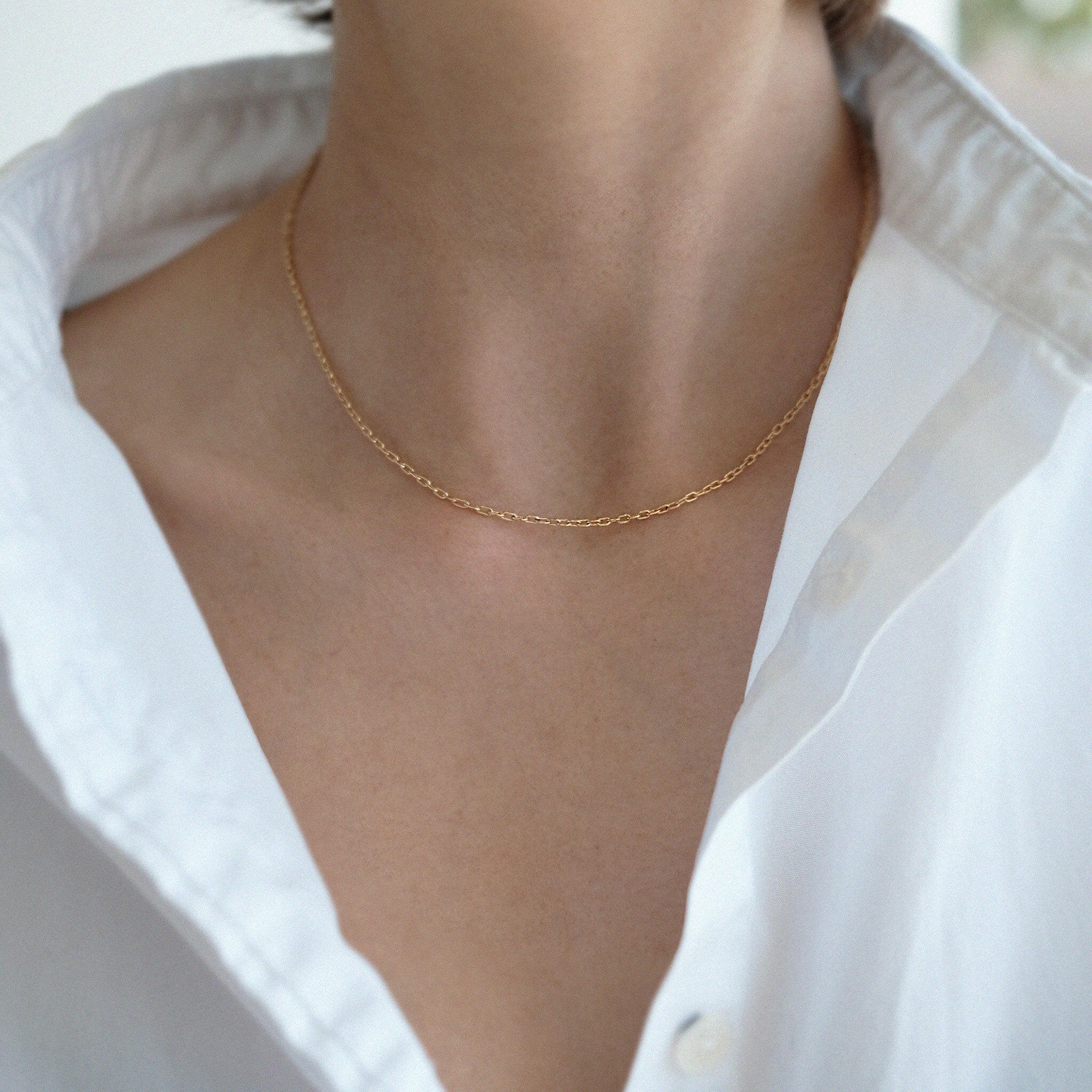 Model wearing Kos necklace alone with neckline exposed