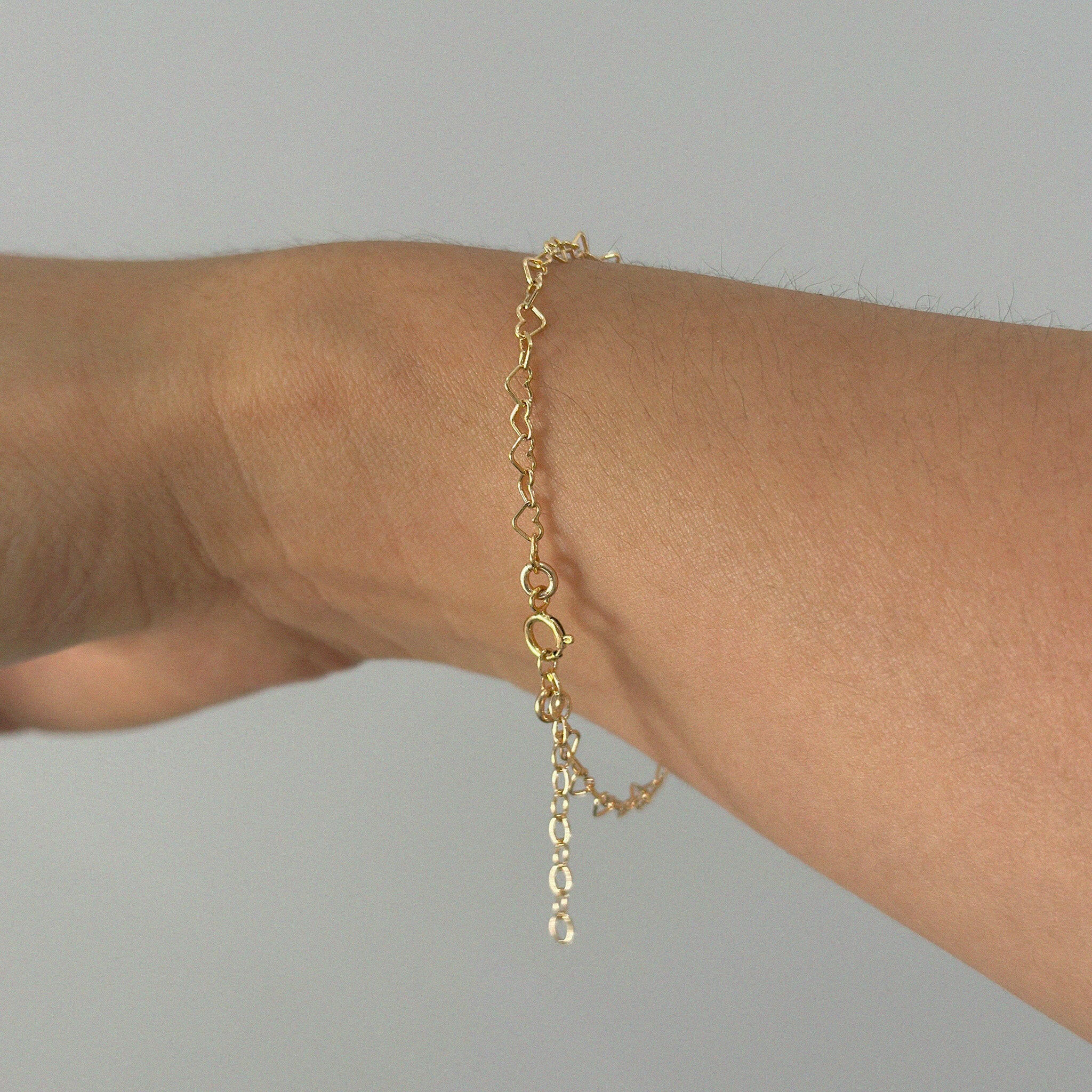 Bracelet worn on wrist, angled to show clasp and extension chain