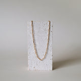 Necklace on stone stand emphasizing structure and finish