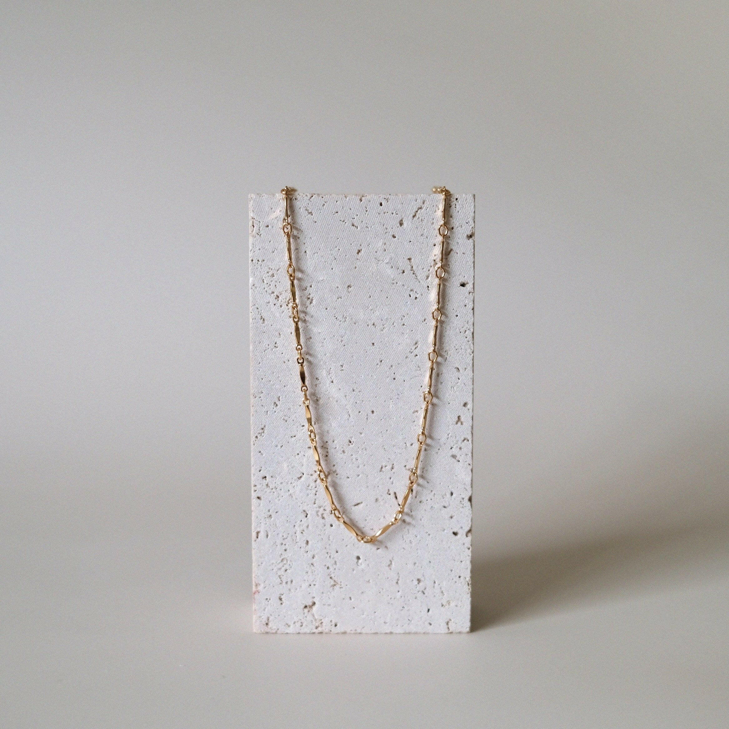 Necklace on stone stand emphasizing structure and finish