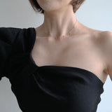 Dainty gemstone necklace styled with a black neckline