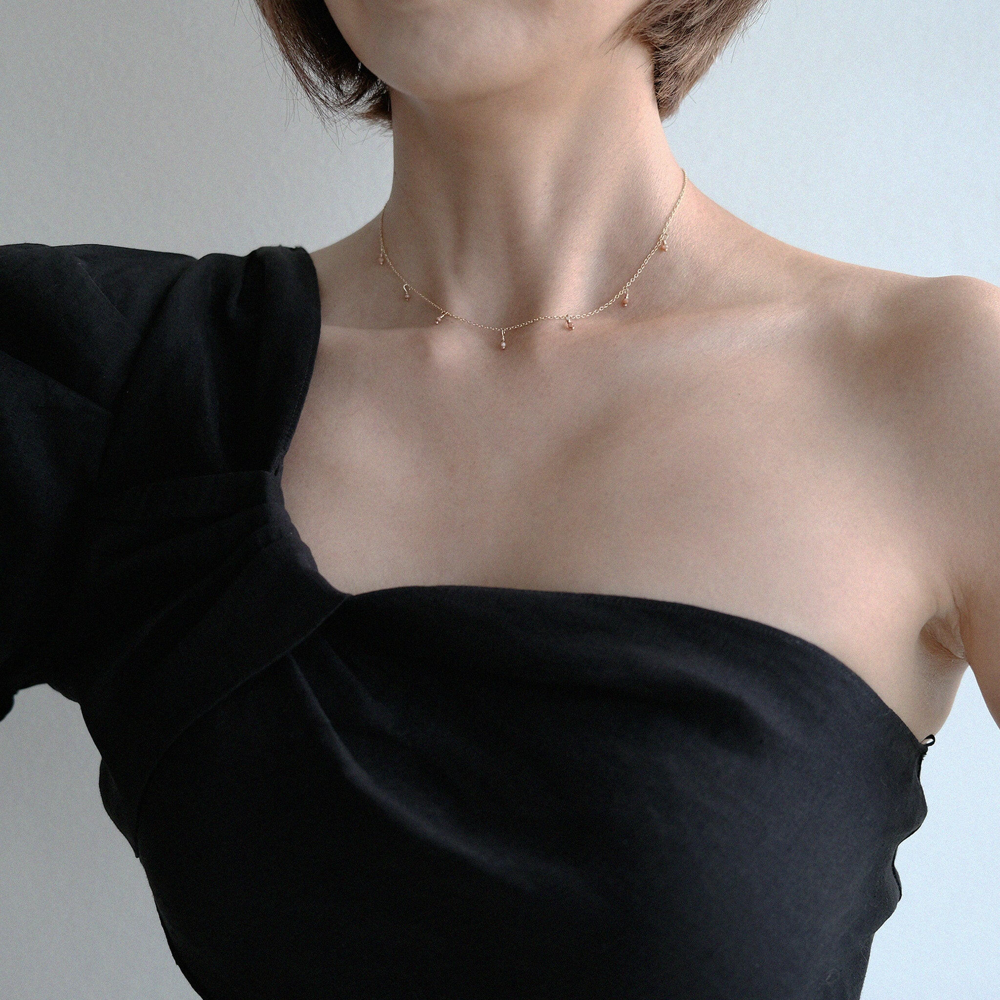 Dainty gemstone necklace styled with a black neckline