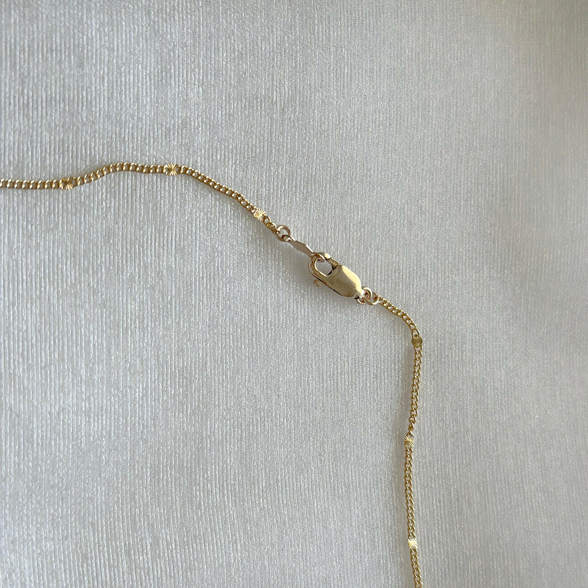 Side angle of lobster clasp and upper chain connection