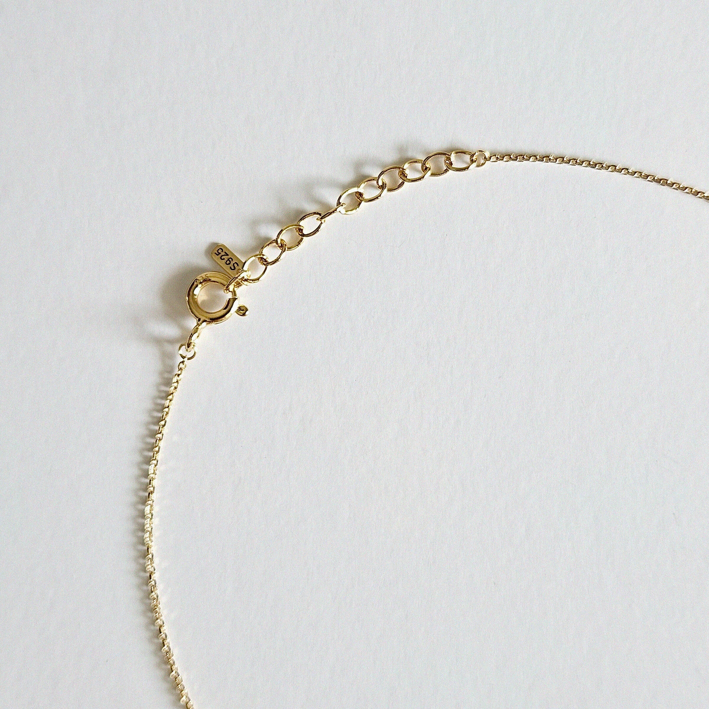 Detailed view of clasp and pendant setting in gold plated finish