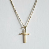 Close-up of rectangular gold cross pendant on a fine chain