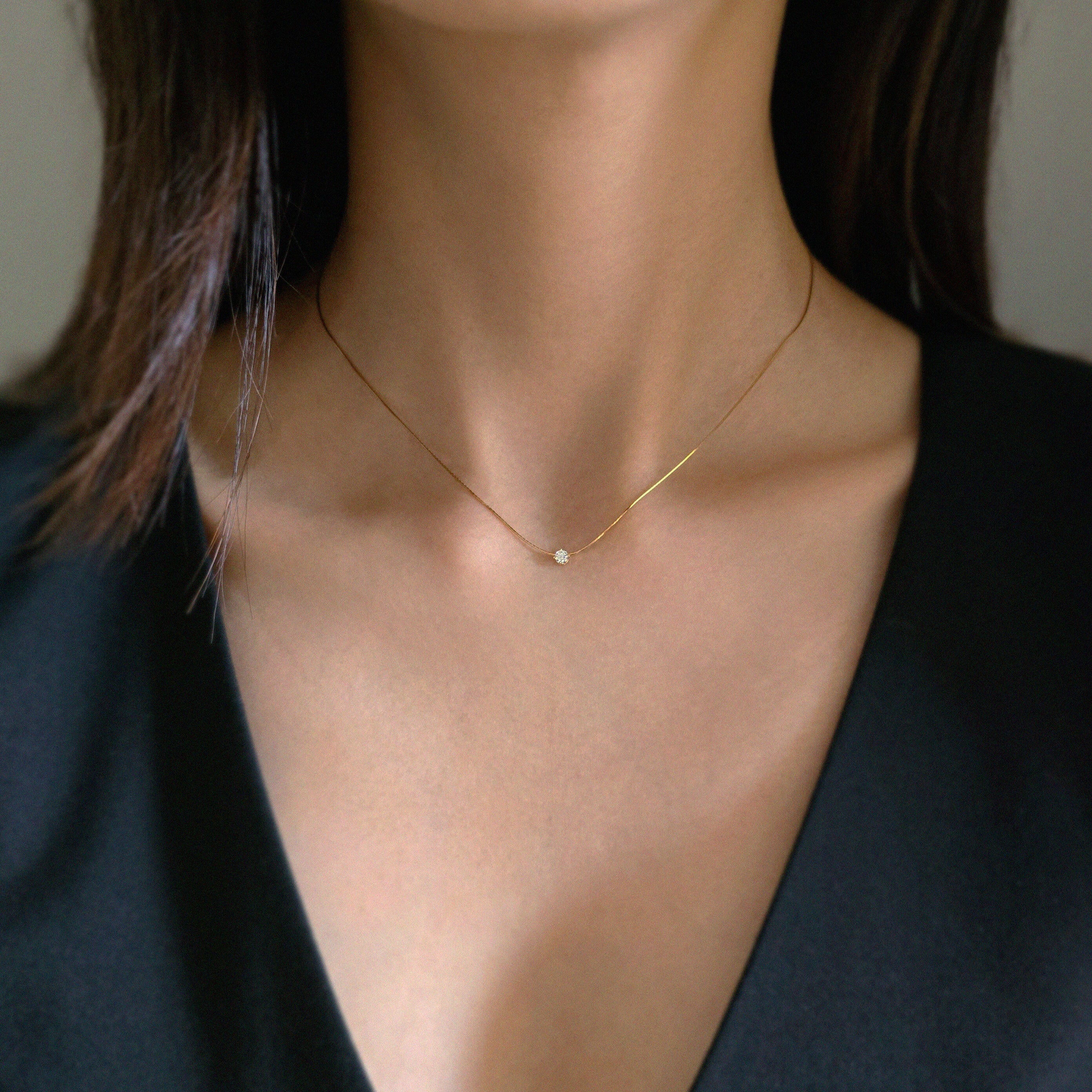 Close-up of neckline showcasing snake chain and zirconia centerpiece