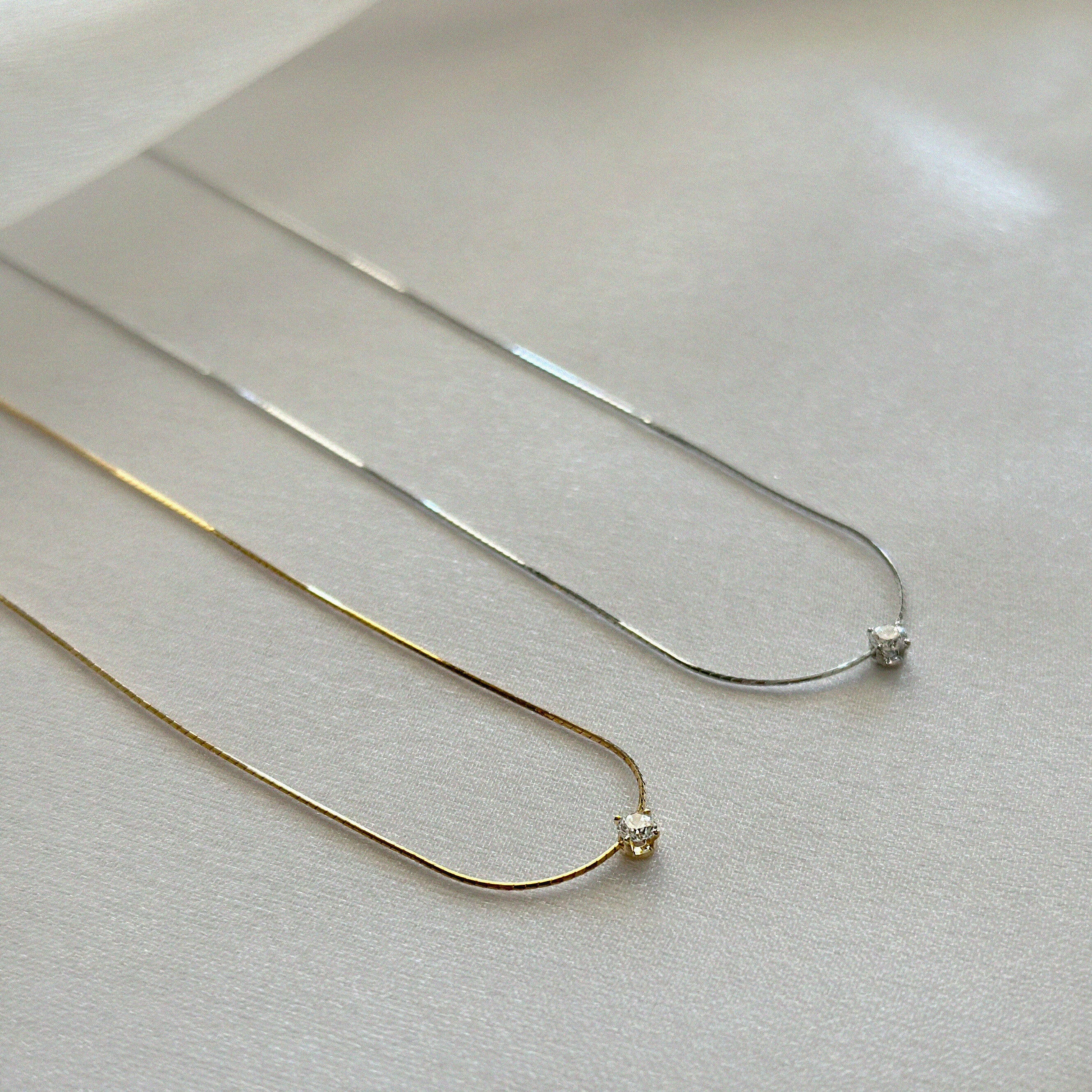 Sterling silver and gold versions of delicate snake chain necklace shown side by side