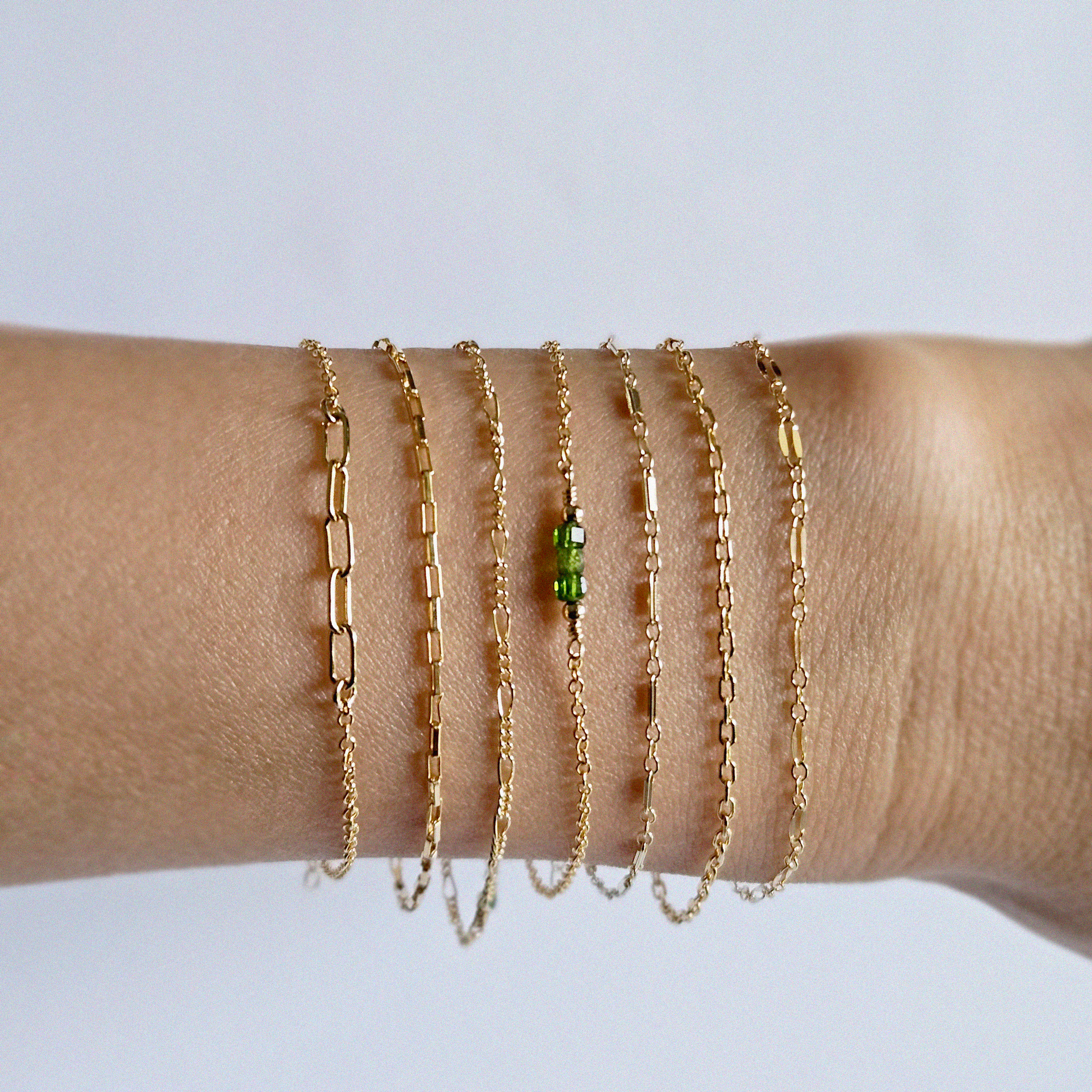 Model wearing multiple of minimal gold filled chain bracelet