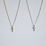 Gold and silver cross necklaces displayed side by side with minimalist cross design