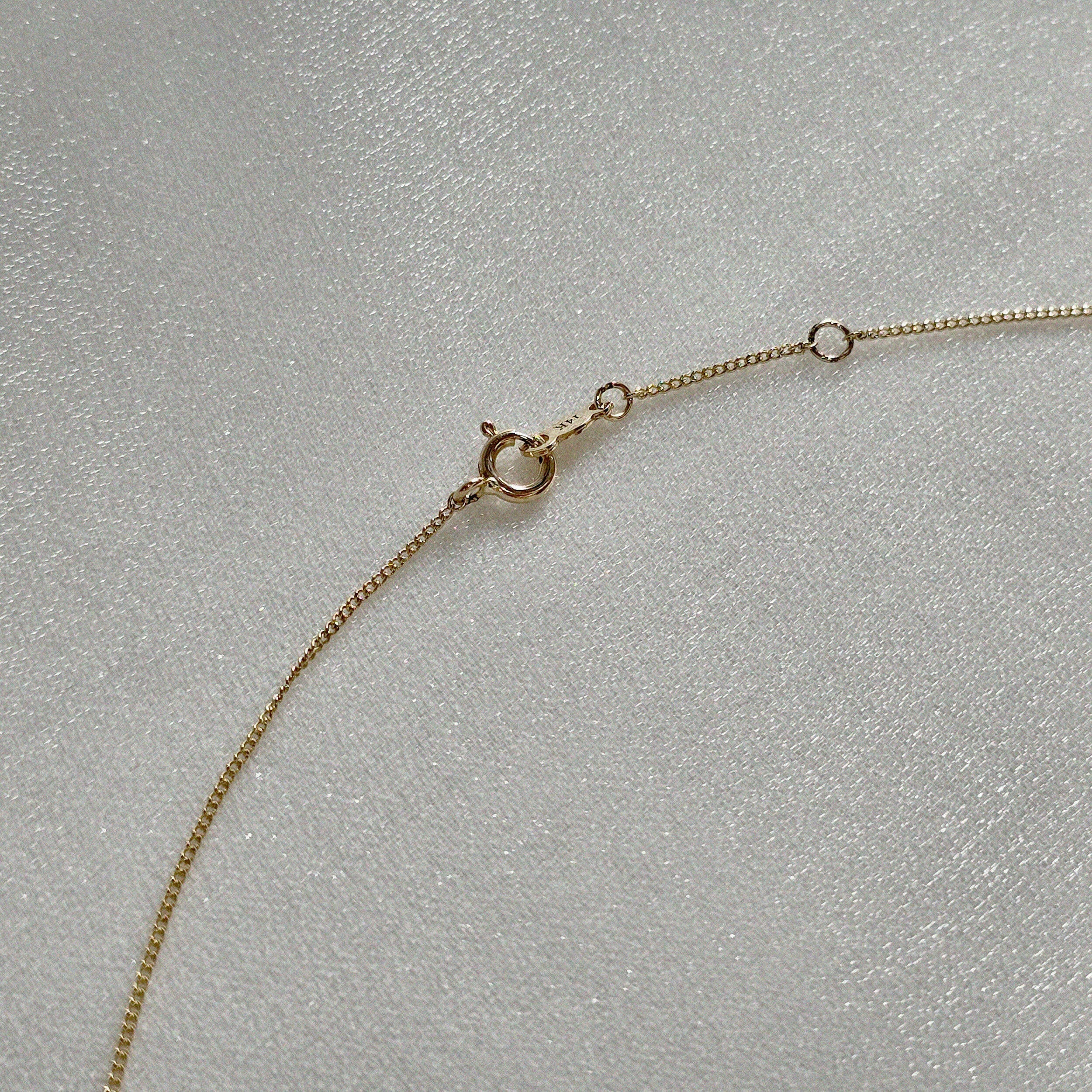 Close-up of spring ring clasp on 14K gold necklace with O-ring extender