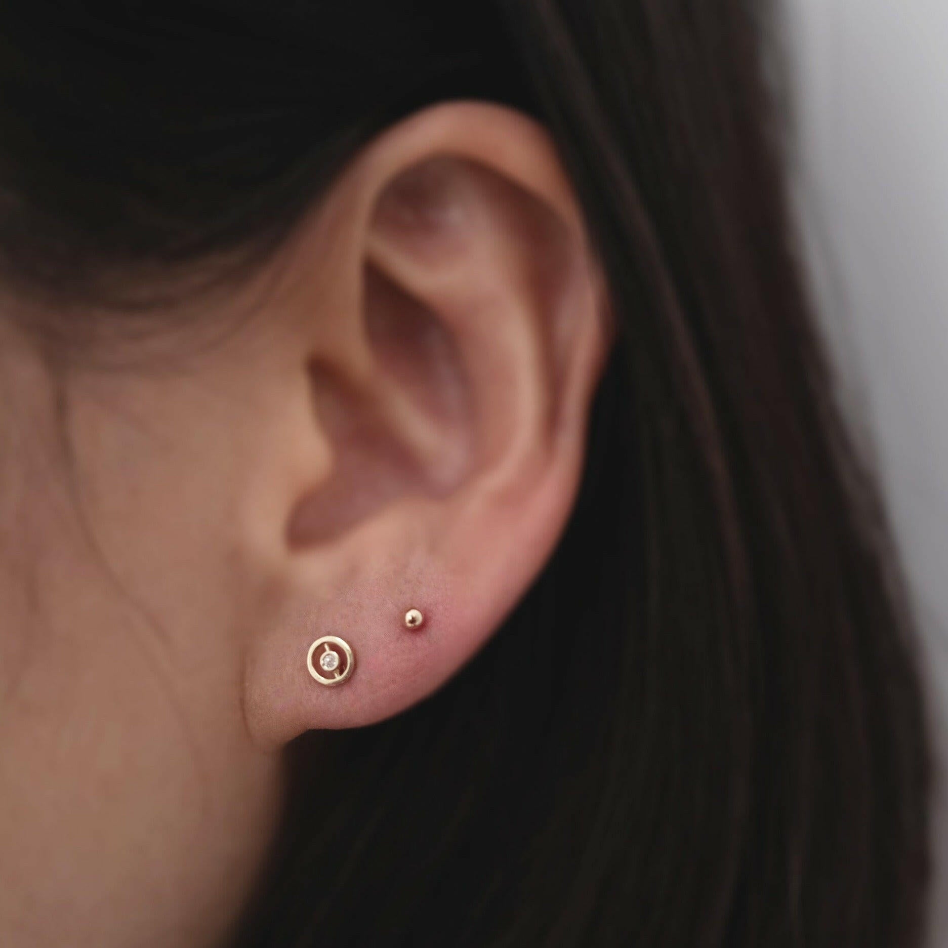 Bishop Circle Studs paired with small gold sphere studs for a layered, modern ear stack