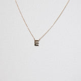 Macro image of 10K solid gold initial necklace with letter E pendant, minimal and shiny