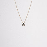 Close-up of 10K gold initial necklace featuring the letter A, with high polish detail in focus