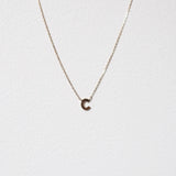 Detailed shot of 10K gold letter C pendant showcasing smooth serif edges on a white background