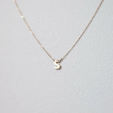 Stylish close-up of letter S initial in polished 10K gold, captured under soft light for clarity