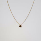 Close-up of circular disc pendant on fine chain