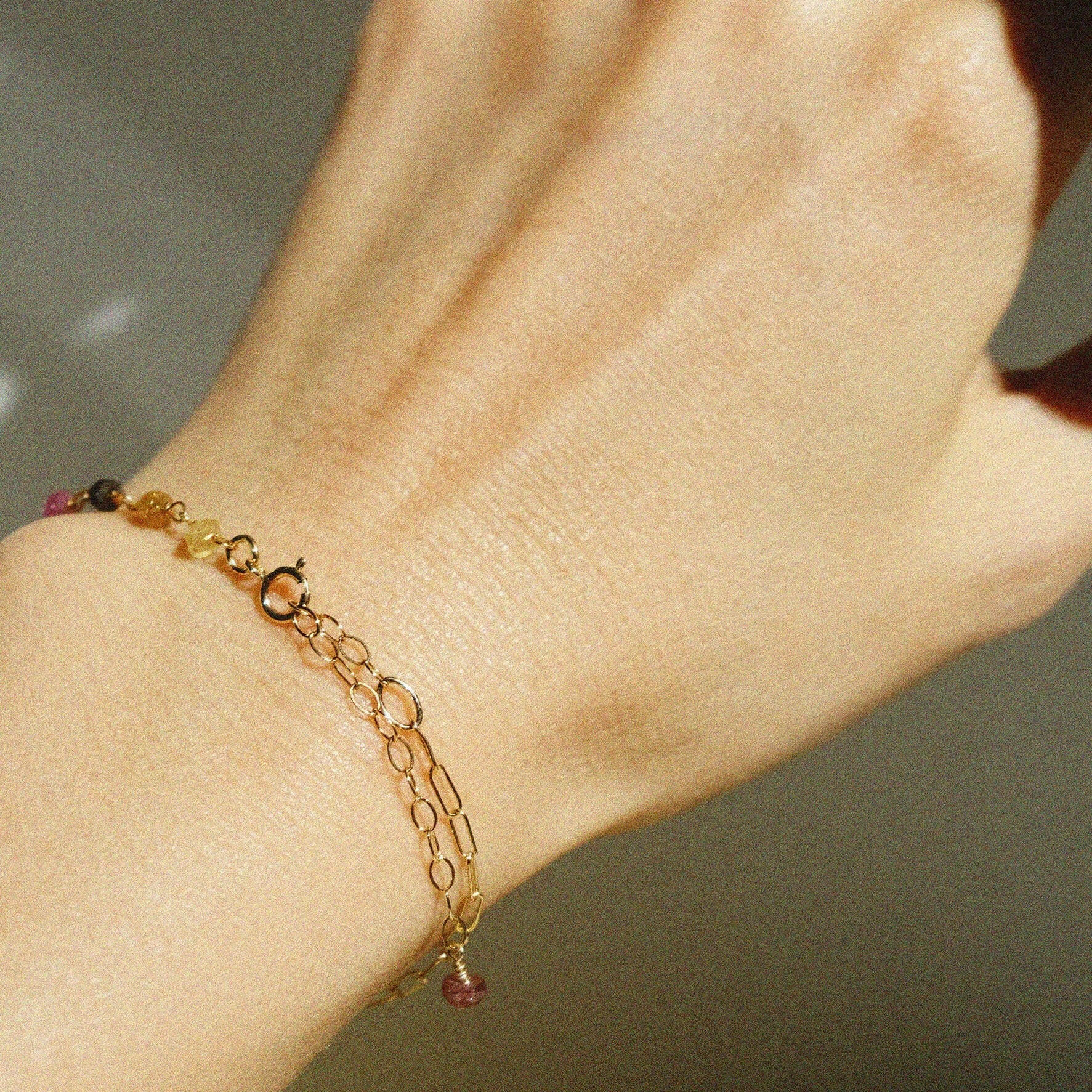 Side angle wrist shot showing clasp and colorful tourmaline stones