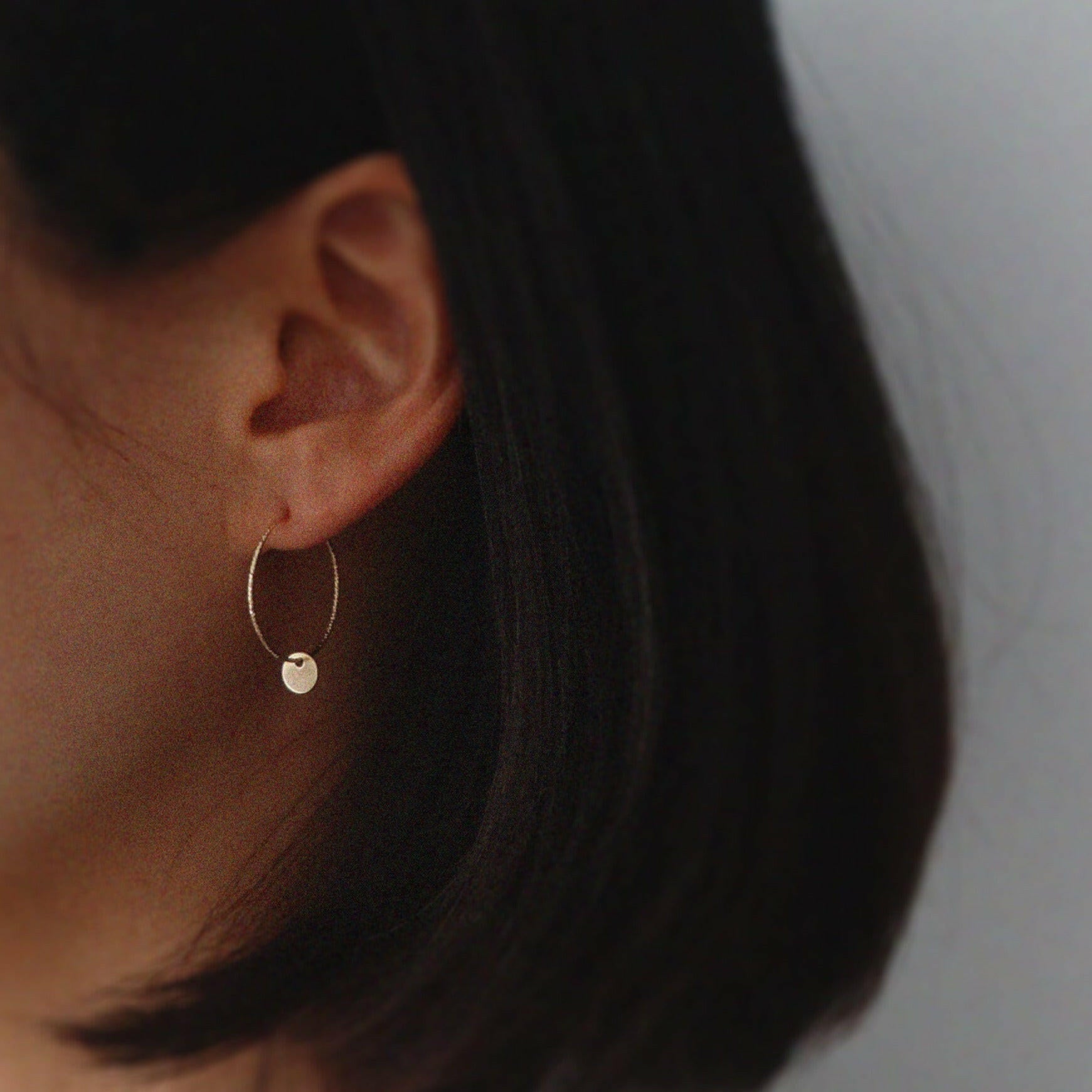 Model wearing Aster Hoops with gold disc accent for a refined minimalist look