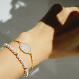 Mari Bracelet paired with link chains and charms in a layered set
