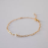Close-up of pearl flanked by polished gold link design