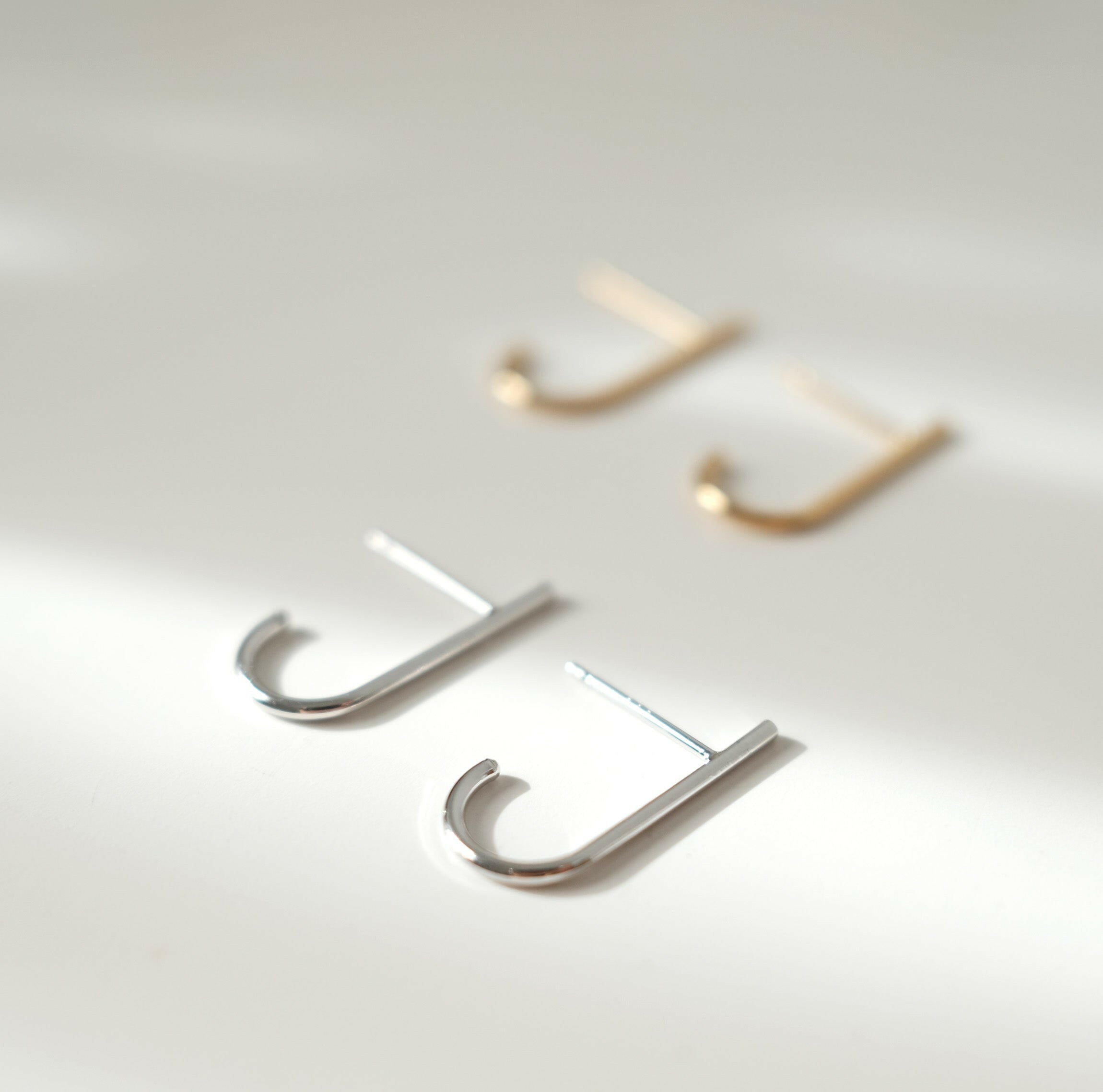 Minimal chic earrings featuring sleek J shaped line for a modern design enhancing elegance and style.