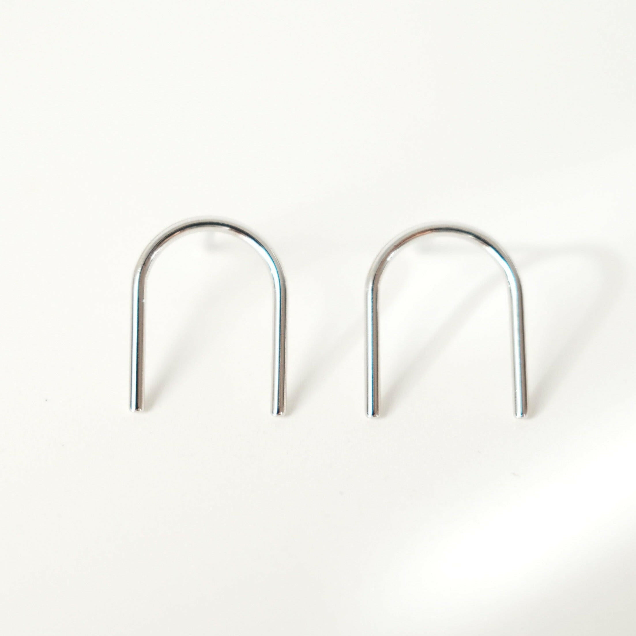 Arch earrings featuring a minimalist line design, sleek and shiny arch line, capturing chic and minimalist style