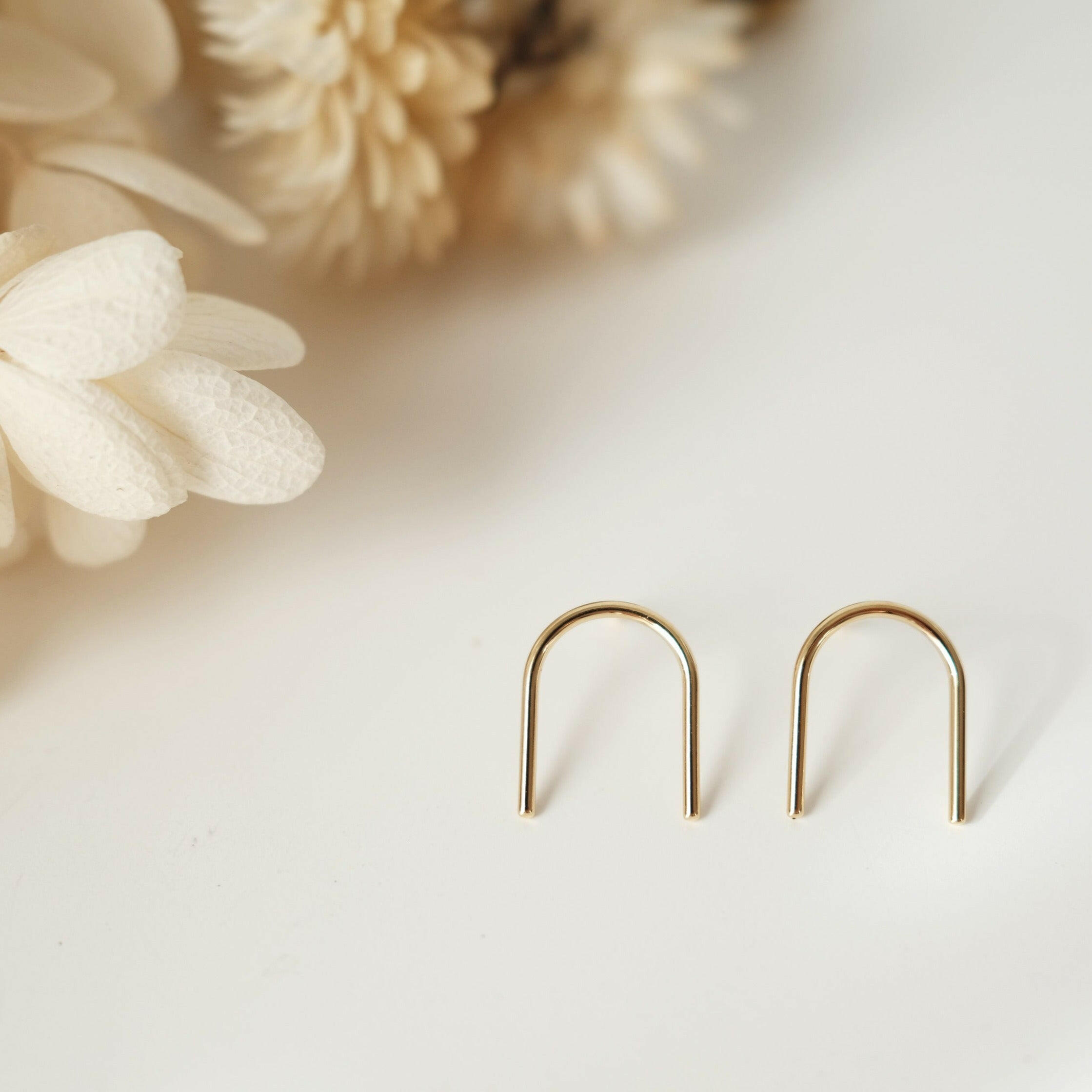 Arch earrings featuring a minimalist line design, sleek and shiny arch line, capturing chic and minimalist style