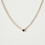 Elegant crystal necklace featuring black cubic zirconia and gemstone on a dainty chain with a petite pendant.