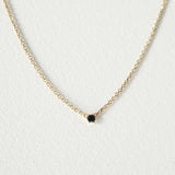 Elegant crystal necklace featuring black cubic zirconia and gemstone on a dainty chain with a petite pendant.