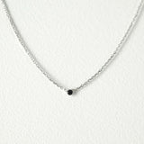 Elegant crystal necklace featuring black cubic zirconia and gemstone on a dainty chain with a petite pendant.